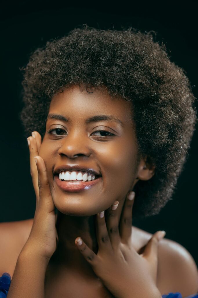 pexels-photo-16874833-16874833 Portrait of a happy, young woman with afro hair, smiling and posing in a studio setting.